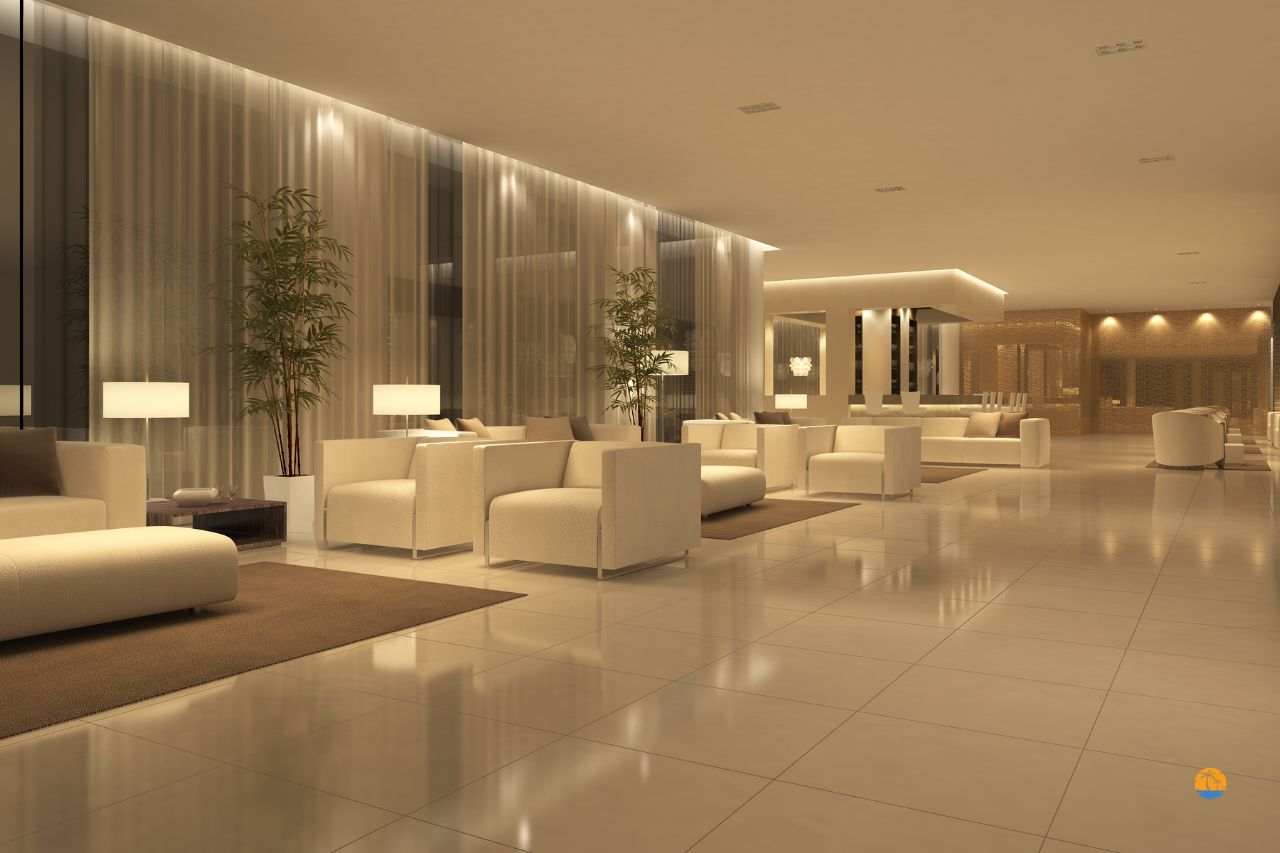 Przestronne lobby hotelowe w jasnych barwach z nowoczesnymi sofami i oświetleniem