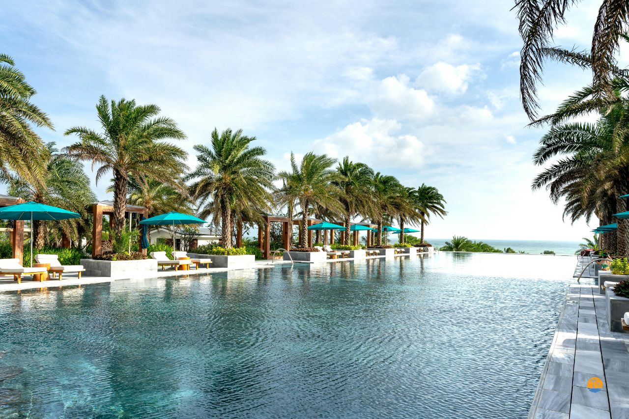 Hotelowy basen z widokiem na palmy i błękitne niebo w tropikalnej okolicy