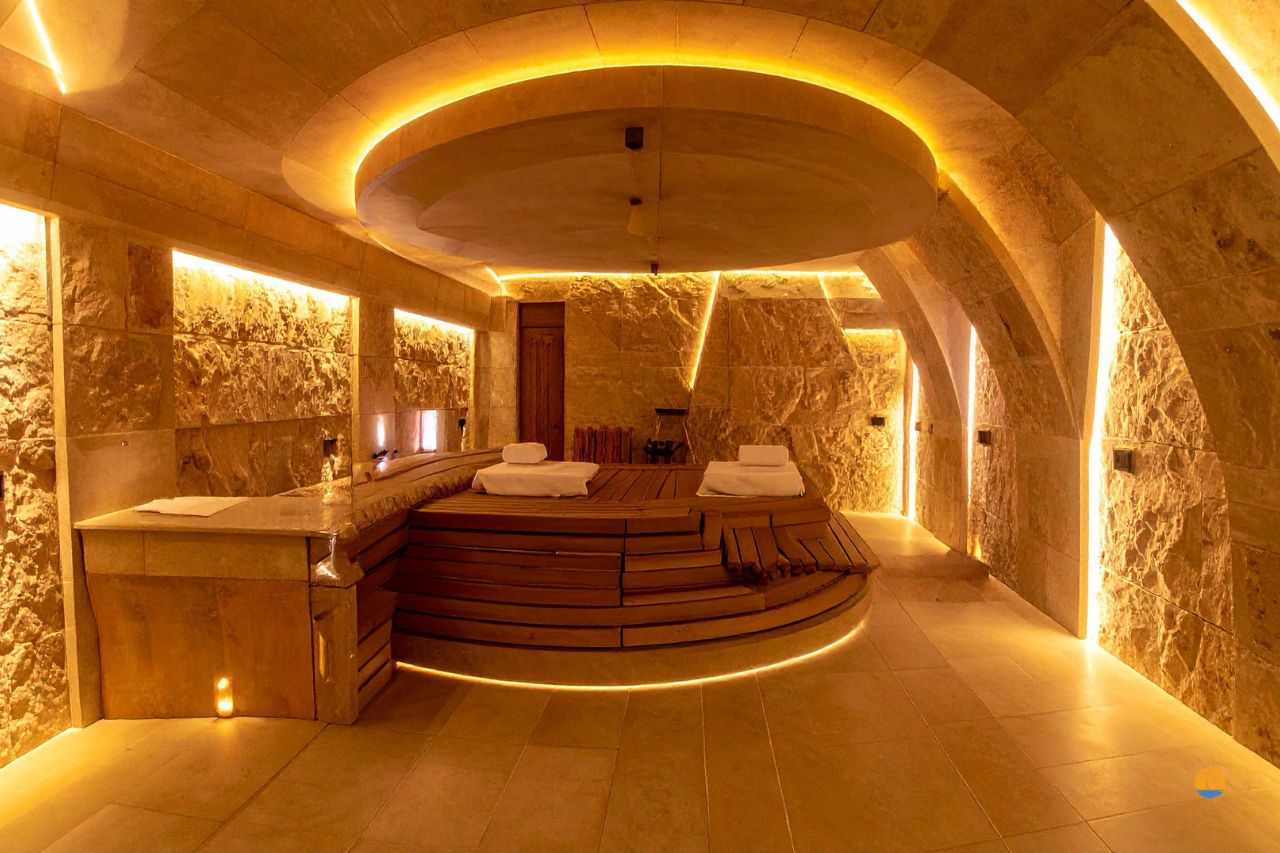 Luksusowa strefa spa z jacuzzi i podświetlanymi łukami w kamiennej aranżacji